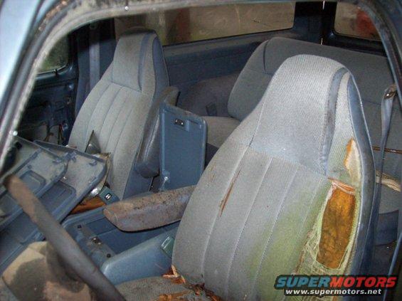 Interior of a truck with torn seats and debris on the floor