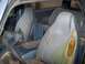 1988 Dodge Power Ram - The interior of the vehicle shows significant wear and tear on the seats and a cluttered floor.