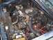 1988 Dodge Power Ram - Engine bay of a vehicle is covered in debris and leaves, obscuring most details.