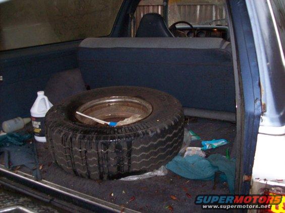 1988 Dodge Power Ram interior with spare tire, cleaning supplies, and blue fabric