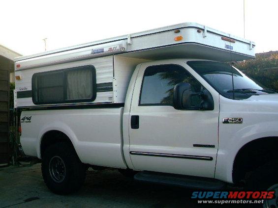 White 2000 Ford F-250 with camper shell, side view