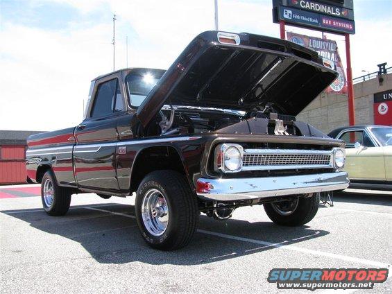 Brown 1964 Chevrolet C10 pickup with hood open, parked next to a yellow car