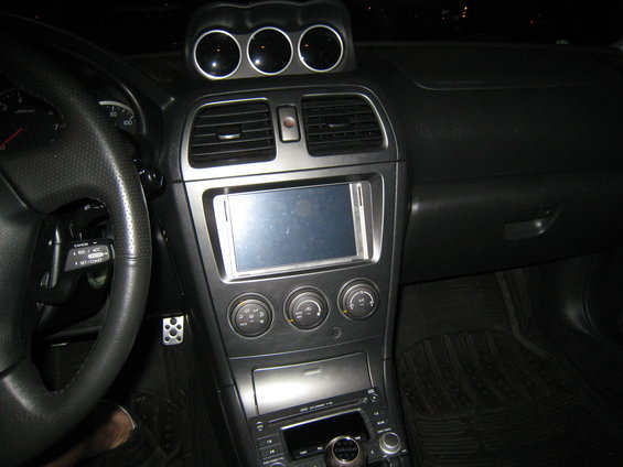 Dashboard of a 2007 Subaru Impreza with a touchscreen stereo and three gauges above the vents