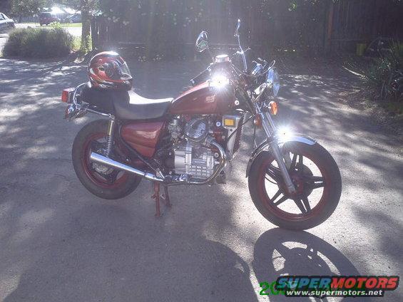 Red 1980 Honda CX500 motorcycle parked outdoors with a helmet on the seat