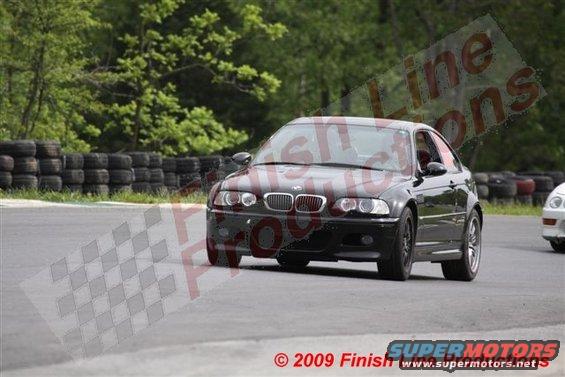 Black BMW M3 on a race track, another car visible to the right