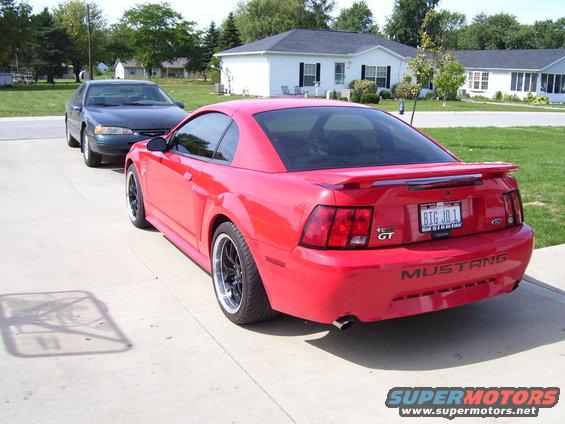 Red 2004 Ford Mustang GT parked on driveway with another car behind it