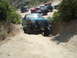 1986 Ford Bronco - A group of modified trucks, including a 1987 Ford F-150, tackle a challenging off-road trail.