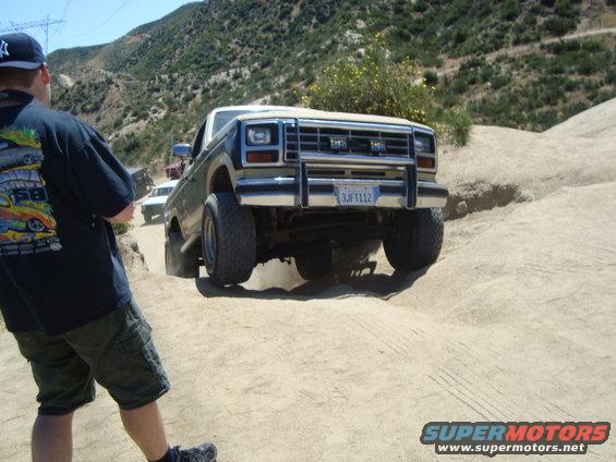 Ford Bronco driving on a dirt trail, another vehicle behind it