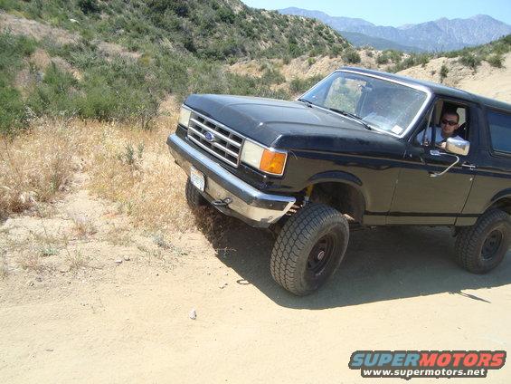 Black 1986 Ford Bronco 3q-front view on a dirt road