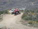 1986 Ford Bronco - Three SUVs navigate a steep, dusty trail in a mountainous, arid landscape.