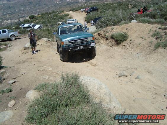 Teal Ford F-Series truck on a rocky trail, front view