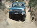 1986 Ford Bronco - Off-road SUV navigating a challenging rocky path.