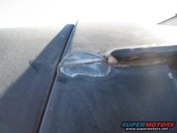 Close-up of a welded seam on a dark-colored vehicle roof