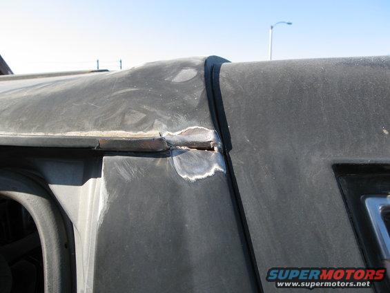 Close-up of a vehicle's roof seam showing welding and body filler work