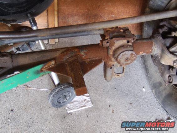 Rusty axle housing with steering linkage and a small wheel