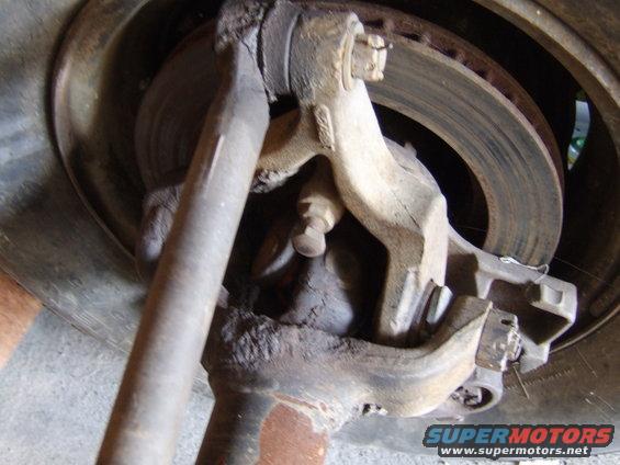 Close-up of front suspension part with brake rotor visible