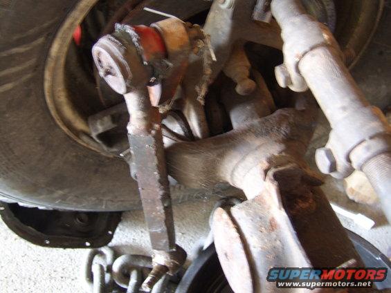 Close-up of a rusty Jeep TJ Dana 44 axle component with a tire visible