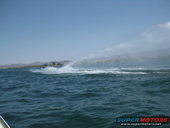 Jet ski spraying water on a lake with mountains in the background