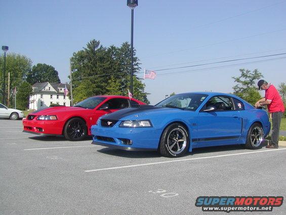 Blue 2004 Ford Mustang and red 2004 Ford Mustang parked side-by-side