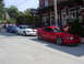 2004 Ford Mustang - Several Ford Mustangs are lined up on a street, with a restaurant in the background.
