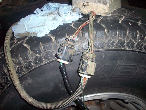 Wiring harness connectors resting on a tire tread