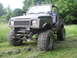 1987 Suzuki Samurai - This heavily modified SUV sits high on its suspension with aggressive off-road tires, ready for rough terrain.