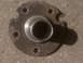 1995 Ford Bronco - Close-up of a rusted wheel hub, likely for an older vehicle, resting on gravel.