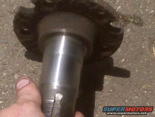 close-up of a metal vehicle spindle held by a thumb