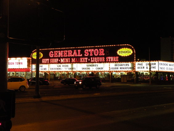 General Store and Bonanza sign with neon lights at night, multiple cars parked in front