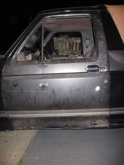 Side view of a black Ford Bronco, showing the driver's door and interior
