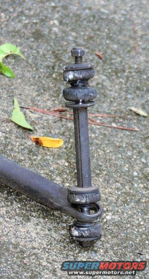 Close-up of a suspension linkage with rubber bushings and a bolt