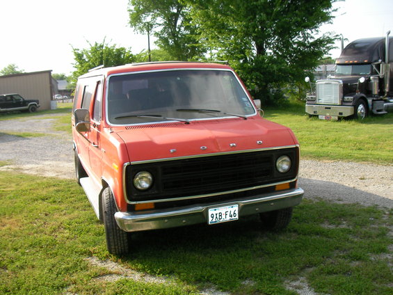Red 1978 Ford E150 van, 3/4 front view, parked on grass