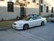 2003 Acura TL - A white 2003 Acura TL sedan is parked on a street in front of a building, with a white pickup truck visible in the background.