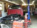 1994 Ford F-250 - Red 1994 Ford F-250 pickup truck chassis undergoing work in a garage.