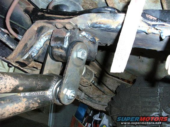 Close-up of welded suspension parts on a vehicle frame, showing bolts and metal brackets