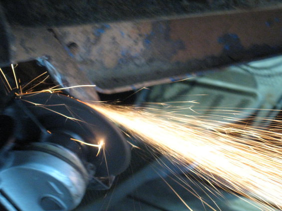 Angle grinder cutting metal, creating a shower of sparks