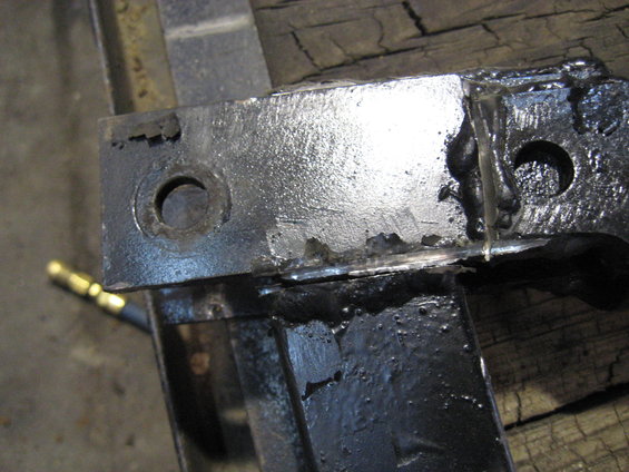 Close-up of a metal bracket with visible welds and bolt holes