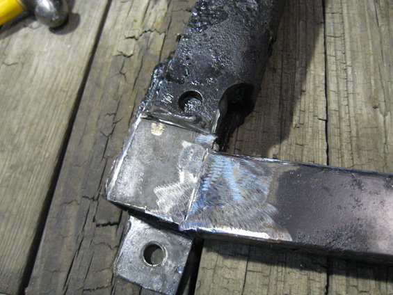 Welded metal brackets with holes on a wooden surface