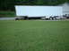 1971 Ford Torino - A 1971 Ford Torino is parked under a large white trailer, with a smaller trailer and another vehicle visible behind it.