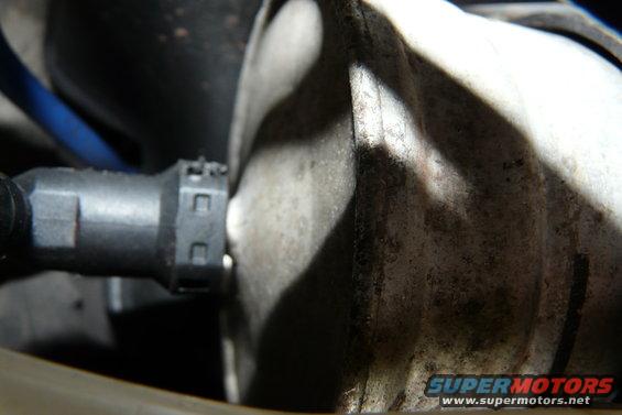 Close-up of a fuel line connector attached to a metal component
