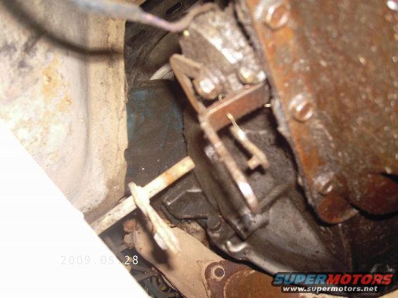 Close-up of a rusty vehicle transmission with visible linkage and bolts