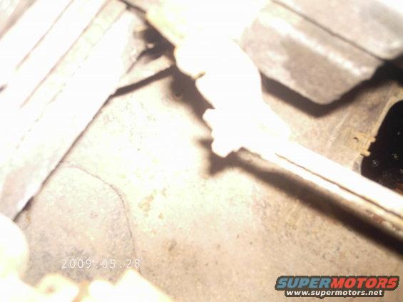 Close-up of a metal part with a white plastic piece attached, date stamp 2009.05.28 visible