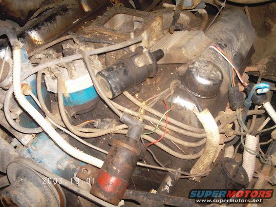 Engine bay with visible ignition coils, wires, and blue engine block components