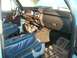 1982 Ford Bronco - The interior of the truck features blue vinyl seats, a wood-grained dashboard, and a radio.