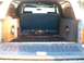 1982 Ford Bronco - The rear cargo area of a vehicle shows custom audio equipment, including two subwoofer boxes and amplifiers.