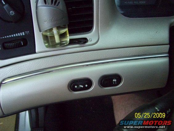 Interior dashboard with air freshener, climate controls, and traction control button