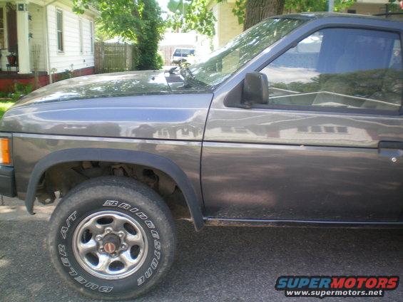 Side view of a gray 1993 Nissan Pathfinder SUV parked outside a house