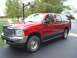 2003 Ford Excursion - This red Ford Excursion SUV is parked in a driveway with a basketball hoop visible.