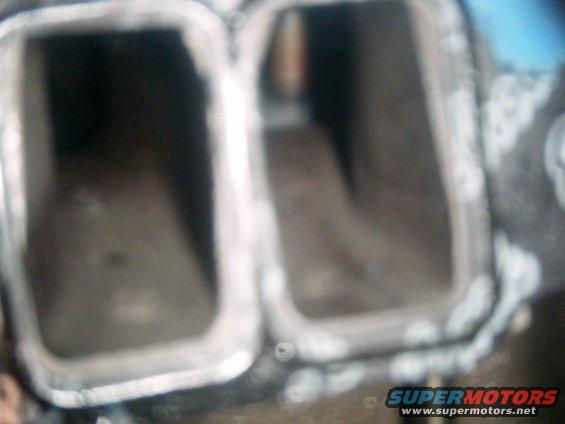 close-up of two rectangular intake manifold ports, one on the left is dark, the one on the right is lighter