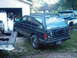 1994 GMC Jimmy - A black 1994 GMC Jimmy SUV is parked in a grassy area next to a garage, with another vehicle visible in the background.